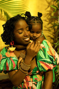 Woman and child in colorful outfits with a yellow background